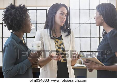 Concerned businesswomen talking in office View Large Photo Image Stock Image - Concerned businesswomen talking in office. Fotosearch