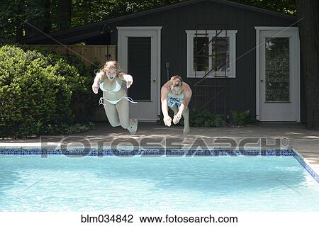 Couple diving into swimming pool in backyard View Large Photo Image Stock Image - Couple diving into swimming pool in backyard. Fotosearch