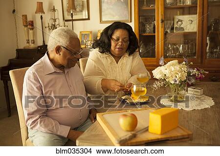 Picture - Couple enjoying wine and crackers in kitchen. Fotosearch