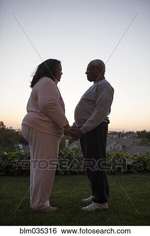 Couple holding hands in backyard View Large Photo Image Stock Photograph - Couple holding hands in backyard. Fotosearch