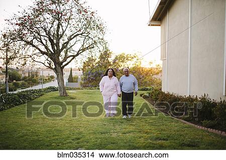 Couple walking in backyard of apartment building View Large Photo Image Picture - Couple walking in backyard of apartment building. Fotosearch