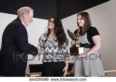 Stock Photo - Debate team receiving award on stage. Fotosearch