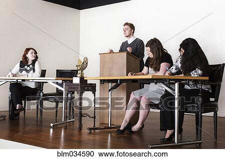 Stock Image - Debate team speaking on stage. Fotosearch