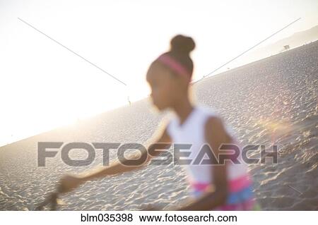 Defocused view of girl riding bicycle on beach View Large Photo Image Stock Photo - Defocused view of girl riding bicycle on beach. Fotosearch