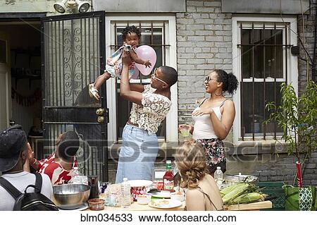 Stock Image - Family enjoying backyard barbecue. Fotosearch