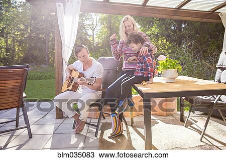 Family relaxing on backyard patio View Large Photo Image Stock Image - Family relaxing on backyard patio. Fotosearch