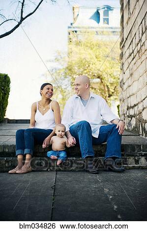 Stock Photograph - Family sitting on urban park steps. Fotosearch