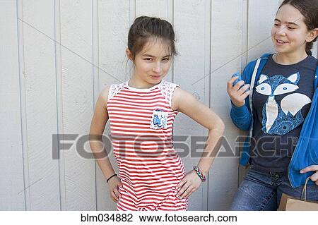 Friend watching girl posing at wall View Large Photo Image Stock Image - Friend watching girl posing at wall. Fotosearch