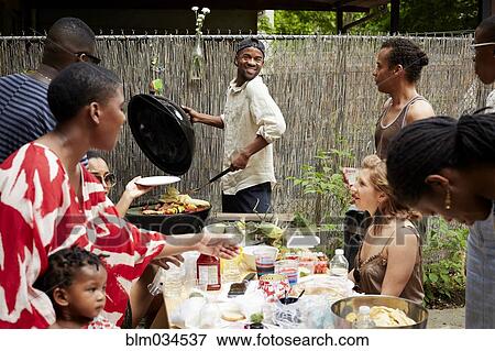 Friends enjoying backyard barbecue View Large Photo Image Stock Photo - Friends enjoying backyard barbecue. Fotosearch