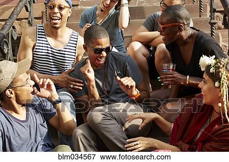 Stock Photo - Friends relaxing on front stoop. Fotosearch