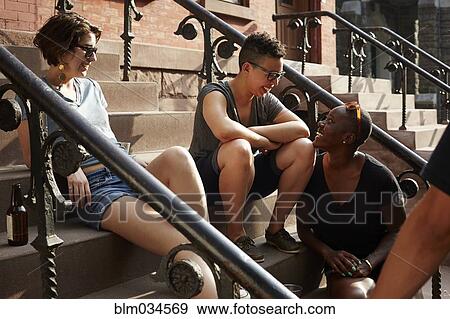 Stock Photo - Friends relaxing on front stoop. Fotosearch