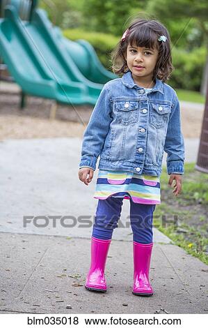Girl wearing rain boots at playground View Large Photo Image Stock Photo - Girl wearing rain boots at playground. Fotosearch