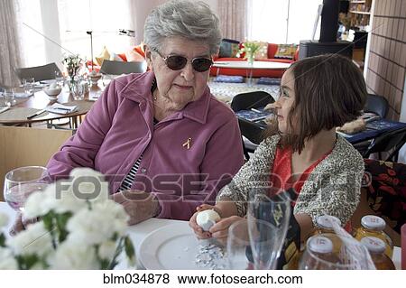 Stock Photo - Grandmother and granddaughter cooking at table. Fotosearch