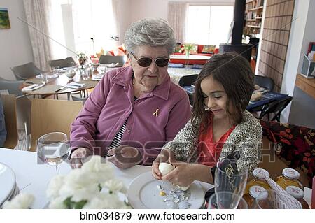 Stock Photo - Grandmother and granddaughter cooking at table. Fotosearch