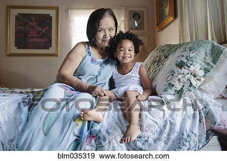 Grandmother and granddaughter hugging on bed View Large Photo Image Stock Photo - Grandmother and granddaughter hugging on bed. Fotosearch