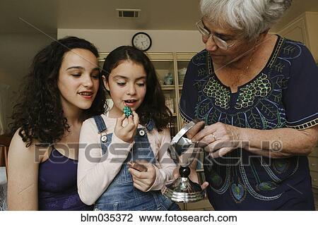 Grandmother helping granddaughters apply lipstick in mirror View Large Photo Image Stock Image - Grandmother helping granddaughters apply lipstick in mirror. Fotosearch