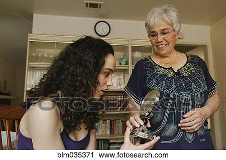 Grandmother holding mirror for granddaughter View Large Photo Image Stock Image - Grandmother holding mirror for granddaughter. Fotosearch