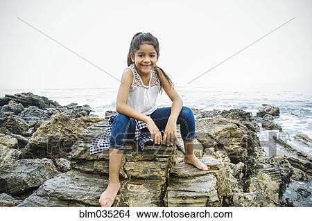 Picture - Hispanic girl exploring tide pools. Fotosearch