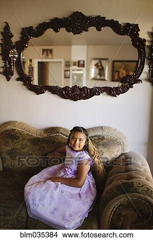 Hispanic girl sitting on living room sofa View Large Photo Image Picture - Hispanic girl sitting on living room sofa. Fotosearch