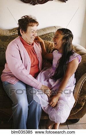 Hispanic grandmother and granddaughter laughing on sofa View Large Photo Image Stock Photography - Hispanic grandmother and granddaughter laughing on sofa. Fotosearch
