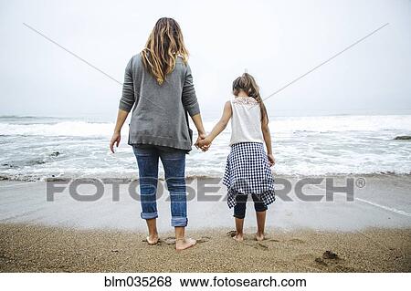 Hispanic mother and daughter standing barefoot on beach View Large Photo Image Stock Photo - Hispanic mother and daughter standing barefoot on beach. Fotosearch