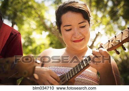 Stock Image - Hispanic musicians performing in park. Fotosearch