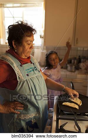 Hispanic woman cooking for granddaughter in kitchen View Large Photo Image Picture - Hispanic woman cooking for granddaughter in kitchen. Fotosearch