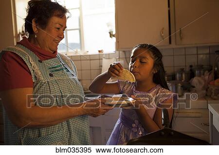 Hispanic woman cooking for granddaughter in kitchen View Large Photo Image Stock Photography - Hispanic woman cooking for granddaughter in kitchen. Fotosearch