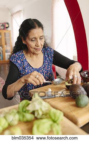Picture - Hispanic woman cooking in kitchen. Fotosearch