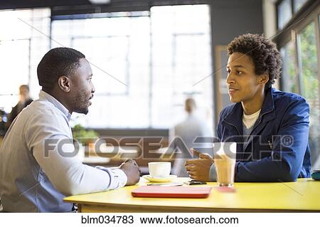 Stock Image - Men drinking coffee in cafe. Fotosearch