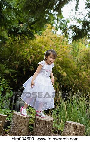 Mixed race girl balancing on logs in park View Large Photo Image Stock Image - Mixed race girl balancing on logs in park. Fotosearch