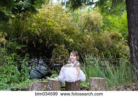 Mixed race girl balancing on logs in park View Large Photo Image Stock Photo - Mixed race girl balancing on logs in park. Fotosearch