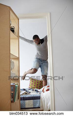 Mixed race woman jumping on bed View Large Photo Image Stock Image - Mixed race woman jumping on bed. Fotosearch
