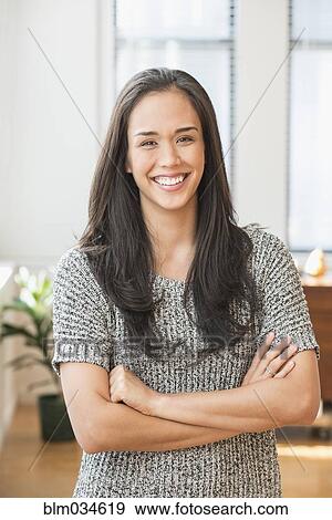 Stock Photo - Mixed race woman smiling with arms crossed. Fotosearch