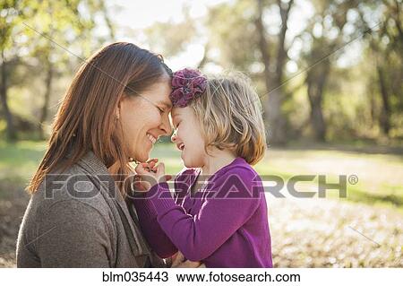 Stock Image - Mother and daughter hugging in park. Fotosearch