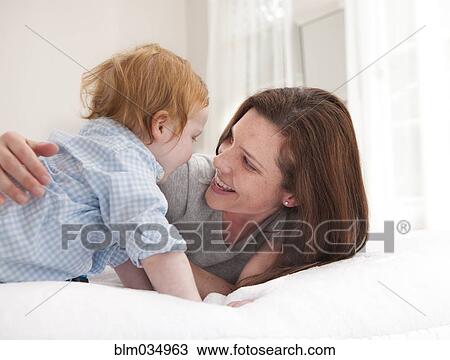 Mother and son playing on bed View Large Photo Image Stock Image - Mother and son playing on bed. Fotosearch