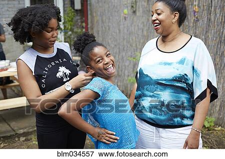 Stock Photo - Mother, daughter and aunt relaxing in backyard. Fotosearch