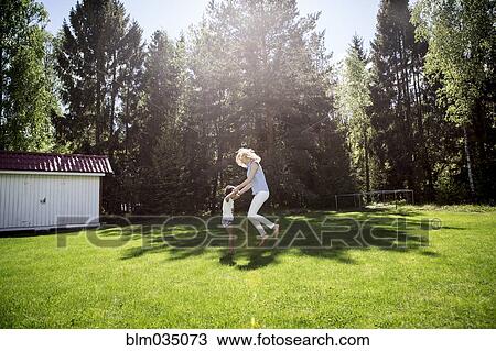 Stock Image - Mother playing with son in backyard. Fotosearch