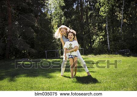Stock Photography - Mother playing with son in backyard. Fotosearch