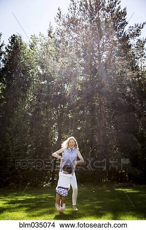 Picture - Mother playing with son near trees. Fotosearch