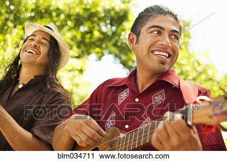 Stock Image - Musicians performing in park. Fotosearch
