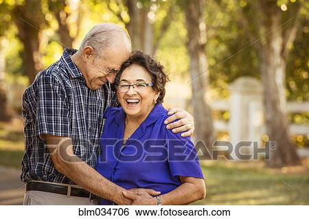 Stock Photograph - Older couple hugging in backyard. Fotosearch