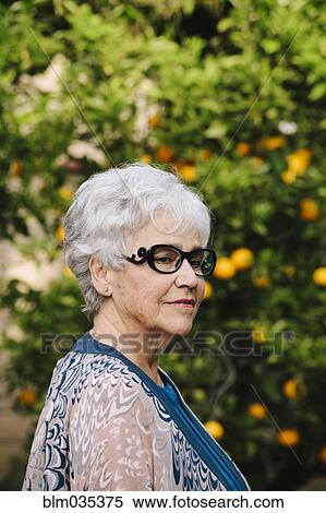 Stock Photography - Older woman standing outdoors. Fotosearch