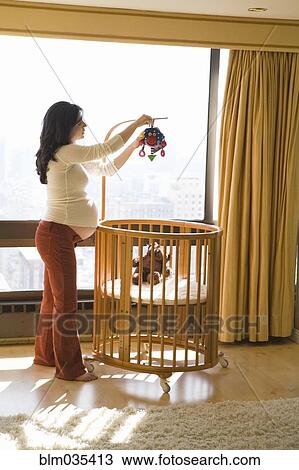 Pregnant woman decorating nursery View Large Photo Image Stock Image - Pregnant woman decorating nursery. Fotosearch