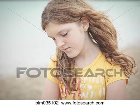 Stock Image - Sad Caucasian girl looking down. Fotosearch