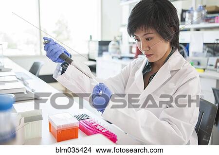 Scientist pipetting liquid into test tube in laboratory View Large Photo Image Picture - Scientist pipetting liquid into test tube in laboratory. Fotosearch