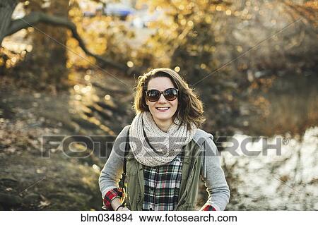Picture - Smiling Caucasian woman walking in park. Fotosearch