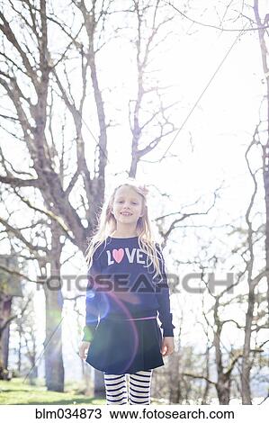 Stock Image - Smiling girl walking in park. Fotosearch