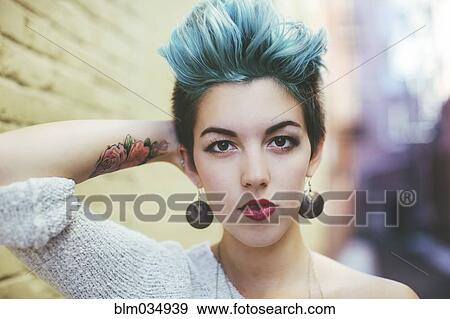 Stock Photo - Stylish Caucasian woman with earrings and dyed hair. Fotosearch