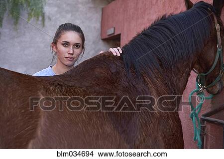 Teenage girl hugging horse at stable on ranch View Large Photo Image Picture - Teenage girl hugging horse at stable on ranch. Fotosearch